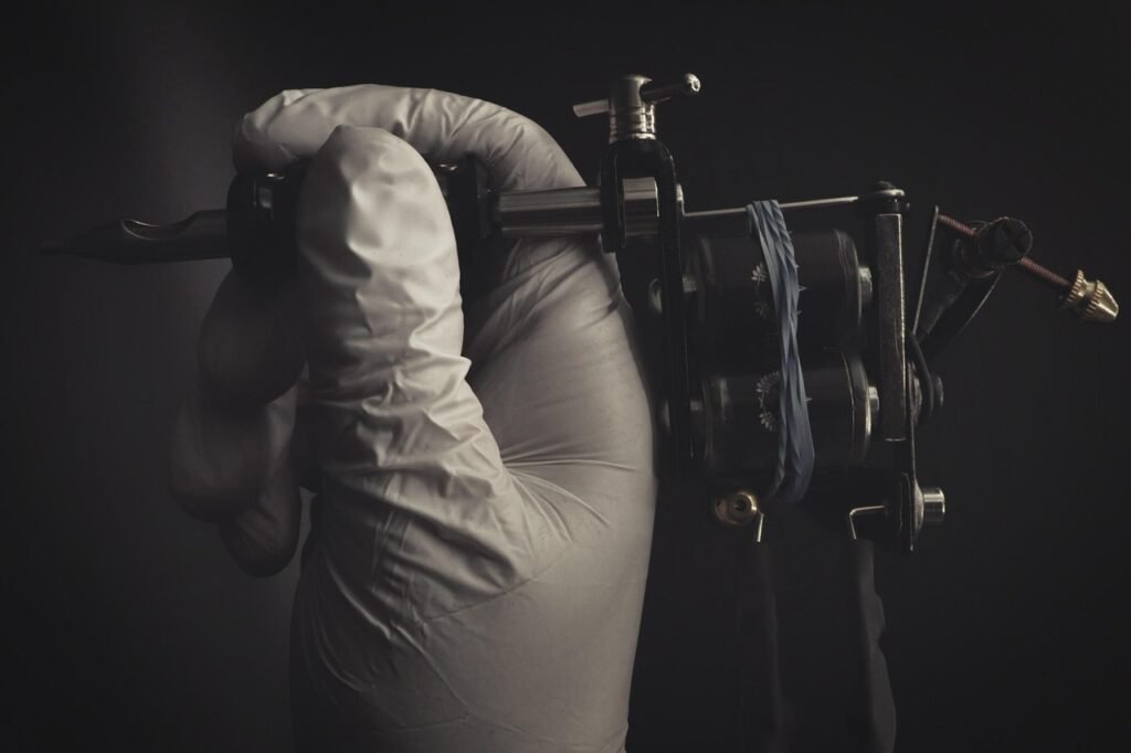 Close-up of a gloved hand holding a tattoo machine, symbolizing consent forms and notarization for tattoo procedures.