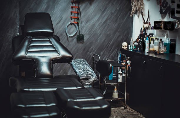 Black leather tattoo chair inside a tattoo studio.